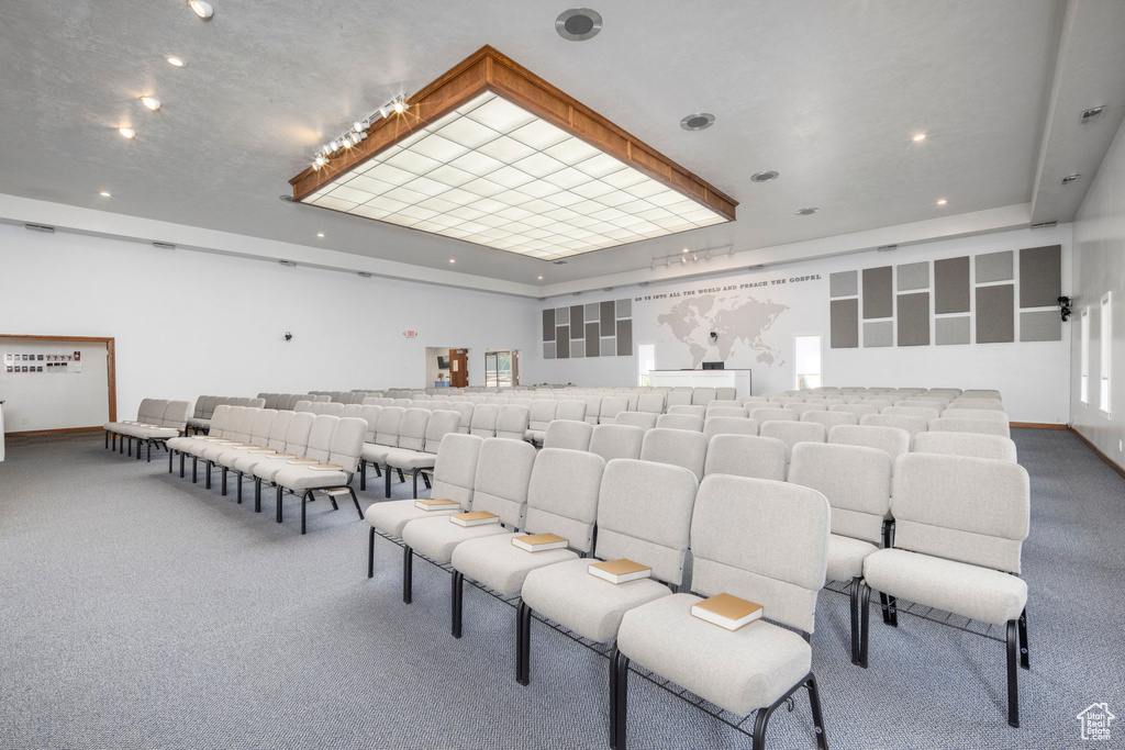 Carpeted home theater with a tray ceiling and recessed lighting