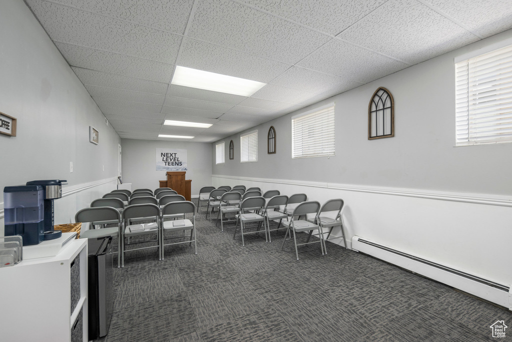 Miscellaneous room featuring a baseboard heating unit, carpet, and a drop ceiling