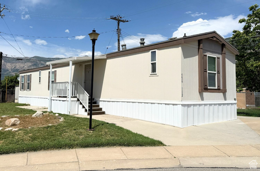 View of front of property featuring a front lawn and a mountain view