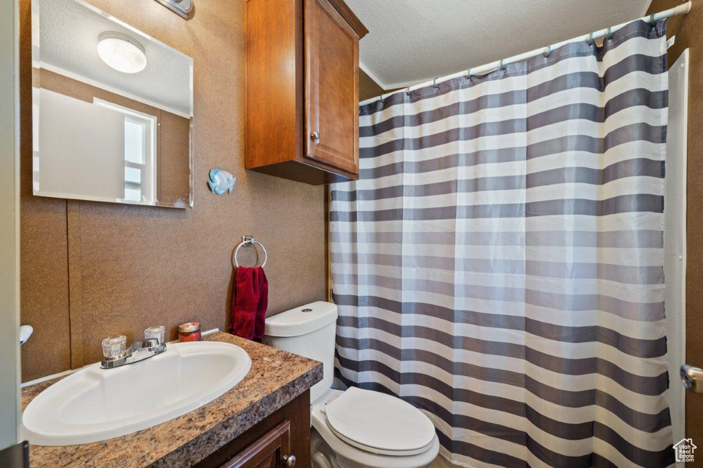 Full bathroom with vanity, a shower with shower curtain, and a textured ceiling