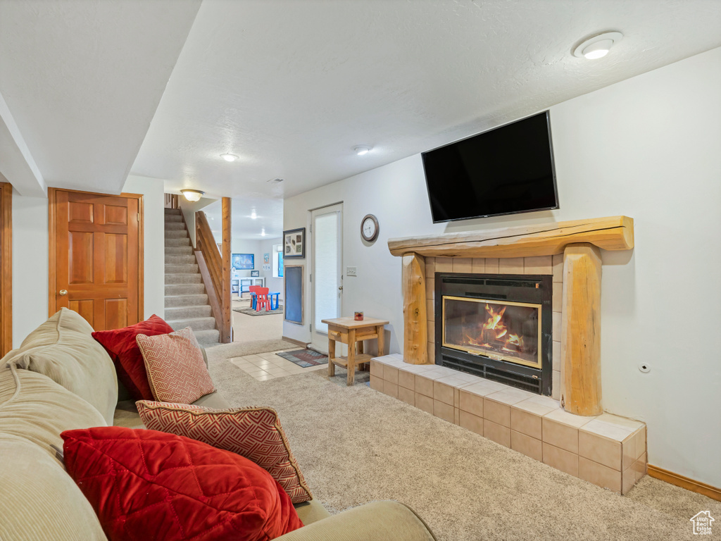 Carpeted living area with stairs and a fireplace