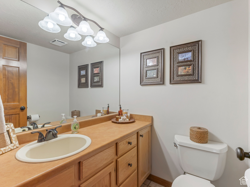 Half bathroom featuring toilet and vanity