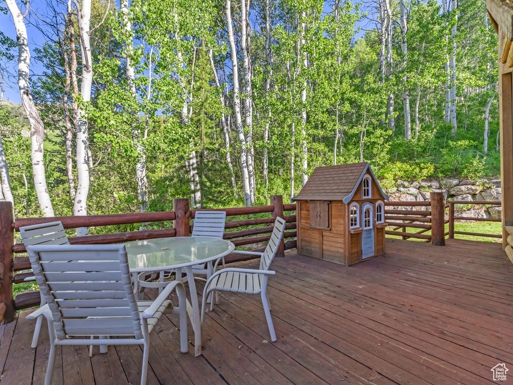 Wooden deck with outdoor dining area and a shed