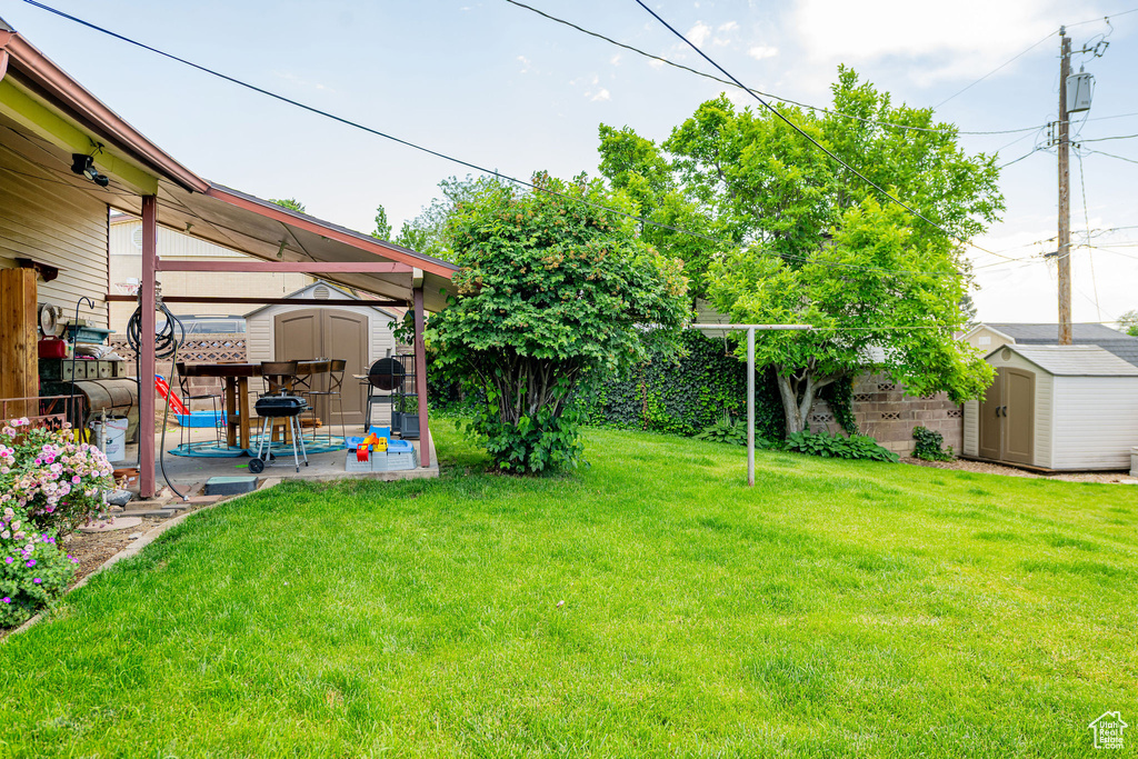 Fenced backyard with a storage shed and a patio area
