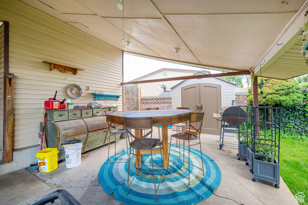 View of patio featuring a storage shed and outdoor dining space