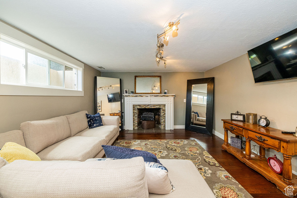 Living area with dark wood finished floors and a stone fireplace