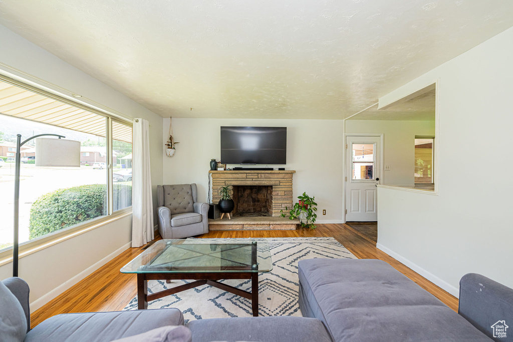Living room with healthy amount of natural light, wood finished floors, and a fireplace