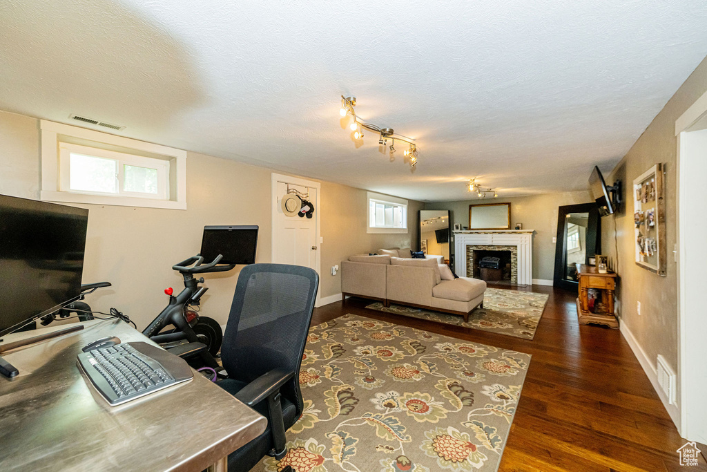Office featuring a fireplace, dark wood-type flooring, and a textured ceiling