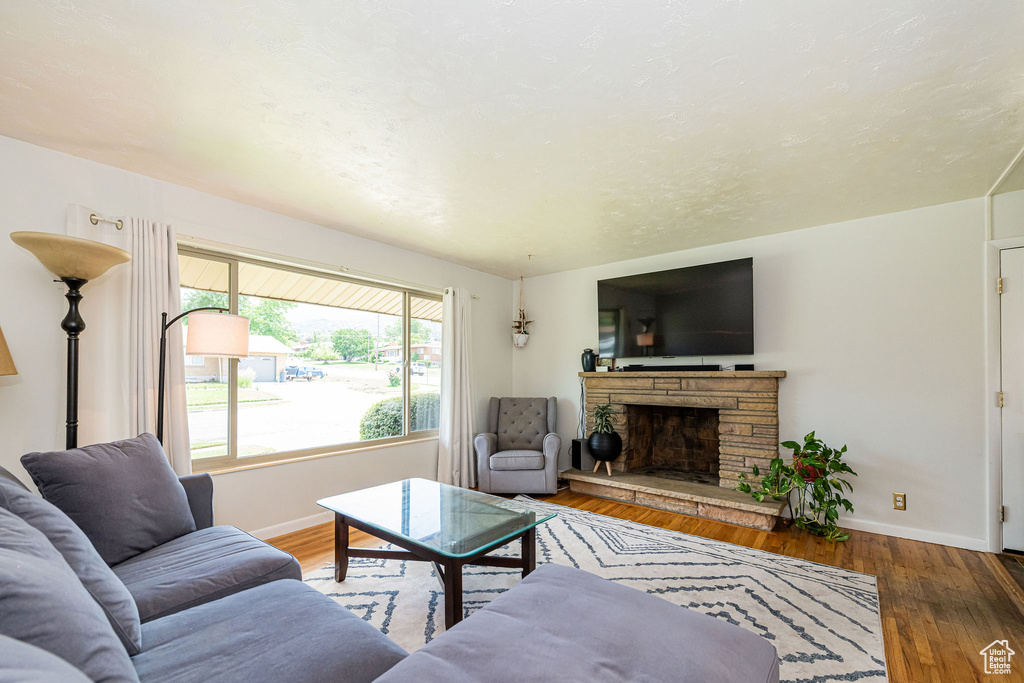 Living room with wood finished floors and a stone fireplace