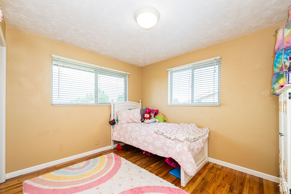 Bedroom with wood finished floors and a textured ceiling