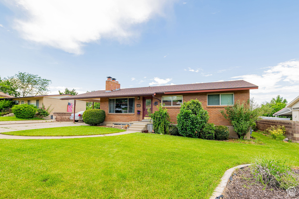 Single story home featuring brick siding, a chimney, and driveway
