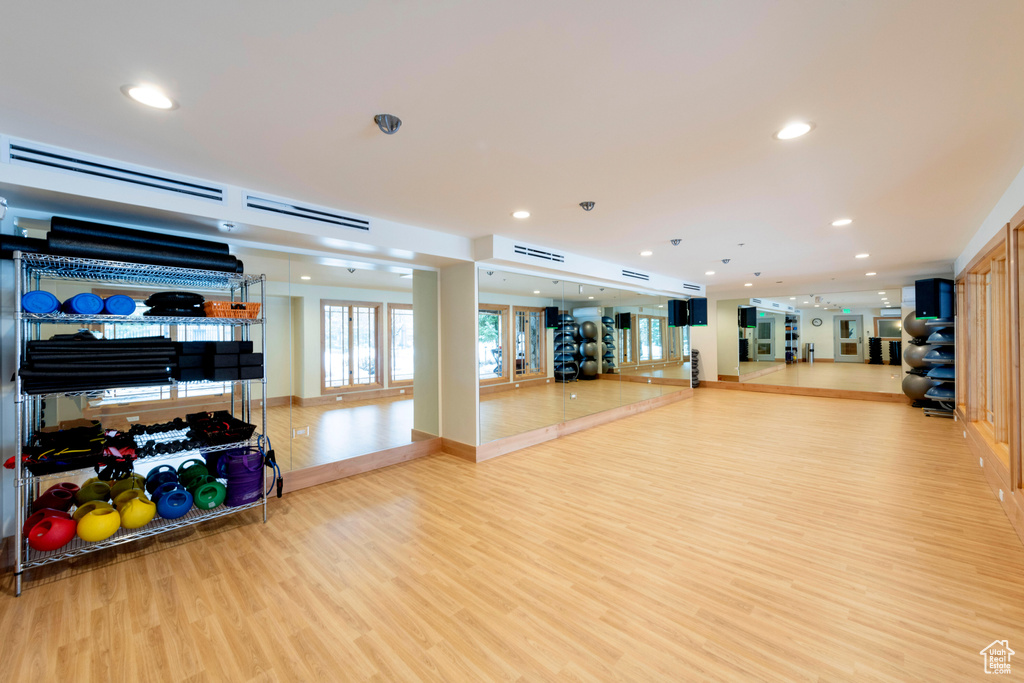 Workout area featuring wood finished floors and recessed lighting
