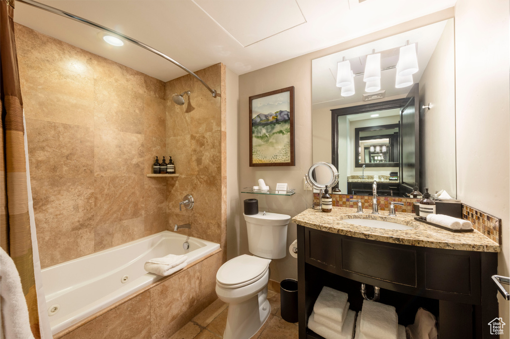 Bathroom featuring a combined bath / shower with jetted tub, vanity, and tile patterned floors