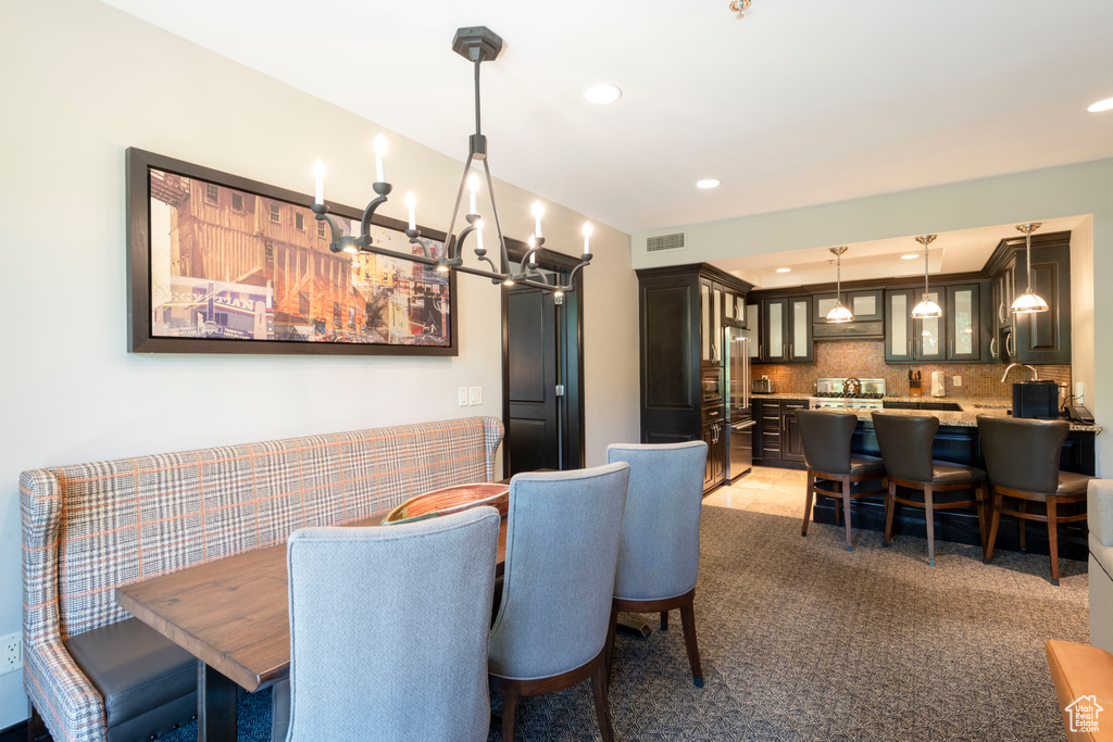 Dining area with recessed lighting, a chandelier, light colored carpet, and bar