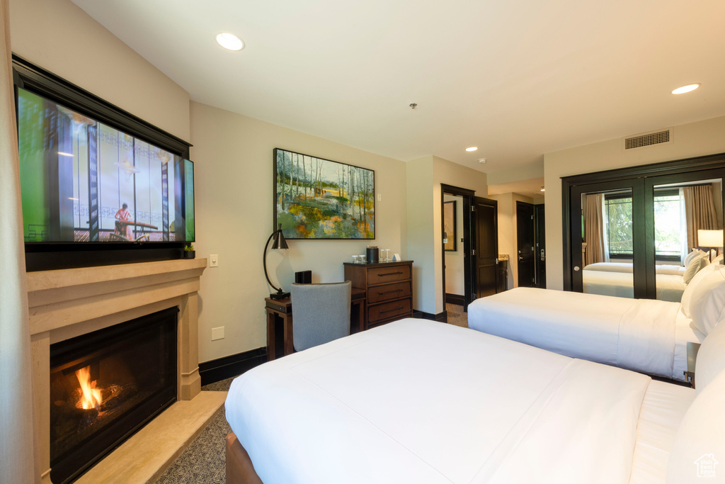 Bedroom featuring recessed lighting and a fireplace with flush hearth