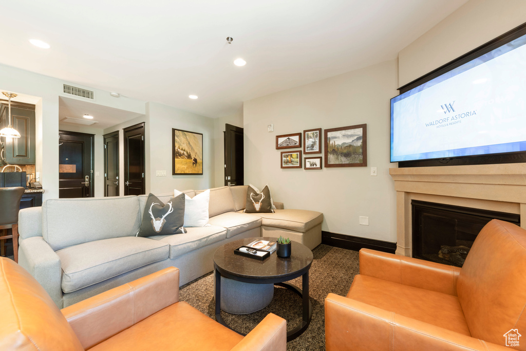 Living area featuring a glass covered fireplace and recessed lighting