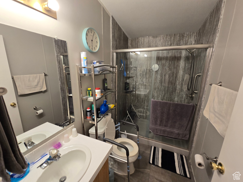 Full bath featuring toilet, a stall shower, vanity, and tile patterned flooring