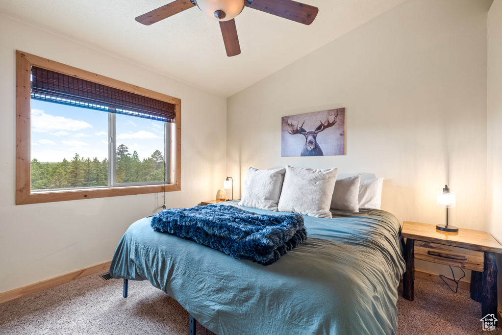 Carpeted bedroom with lofted ceiling and a ceiling fan
