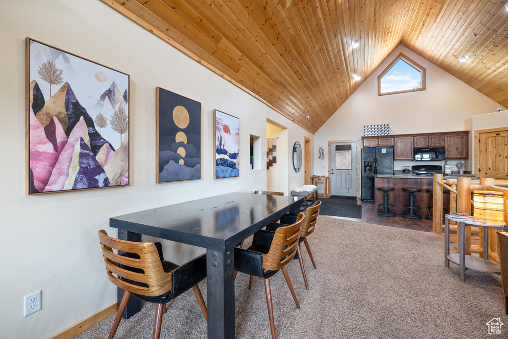 Carpeted dining area featuring wooden ceiling and high vaulted ceiling