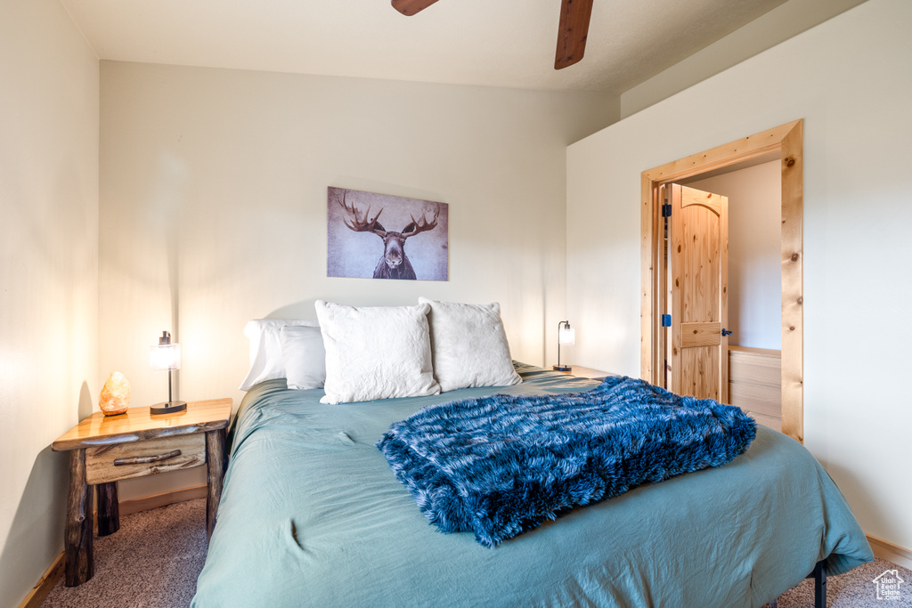 Carpeted bedroom featuring baseboards and a ceiling fan