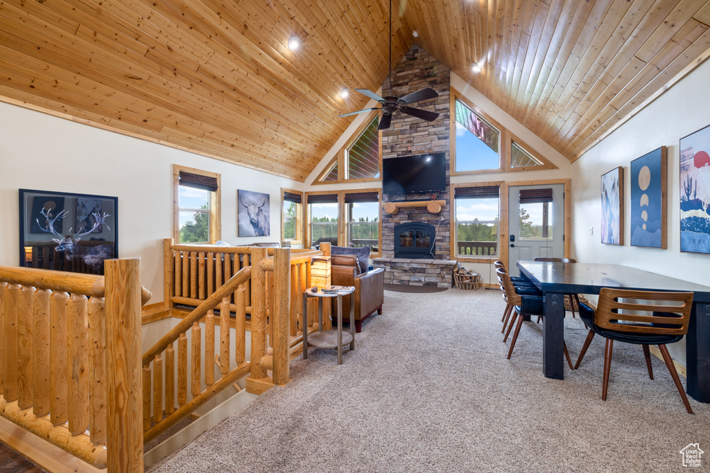 Carpeted living room with high vaulted ceiling, ceiling fan, wood ceiling, a fireplace, and recessed lighting