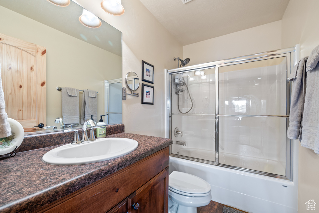 Full bath featuring vanity and shower / bath combination with glass door
