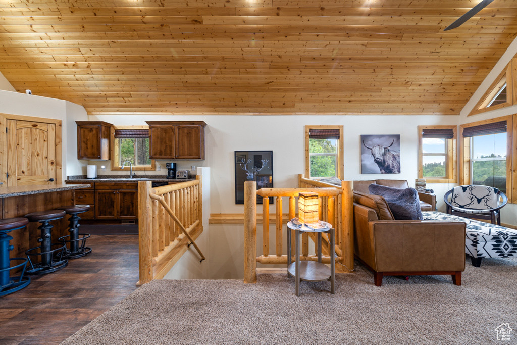 Living room featuring vaulted ceiling, wooden ceiling, and healthy amount of natural light