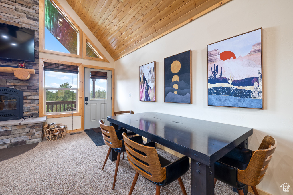Carpeted dining area featuring wooden ceiling and high vaulted ceiling