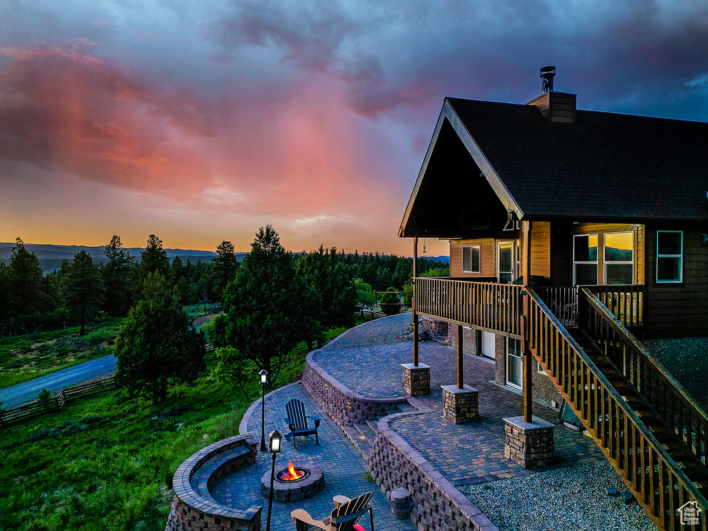 Wooden terrace with a fire pit, a patio, and stairs
