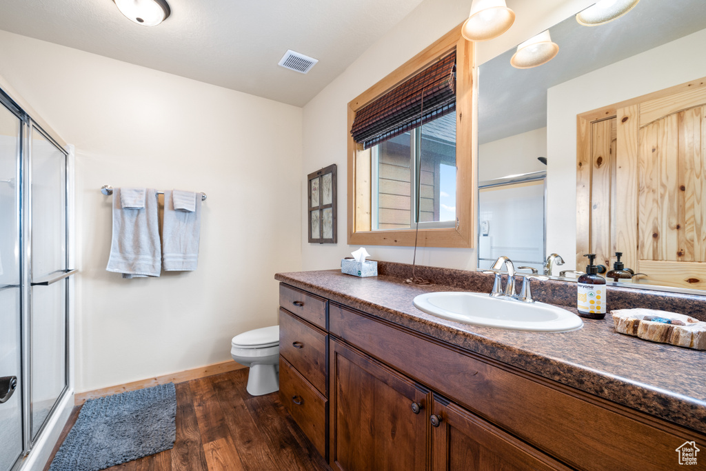 Full bath with a stall shower, wood finished floors, and vanity