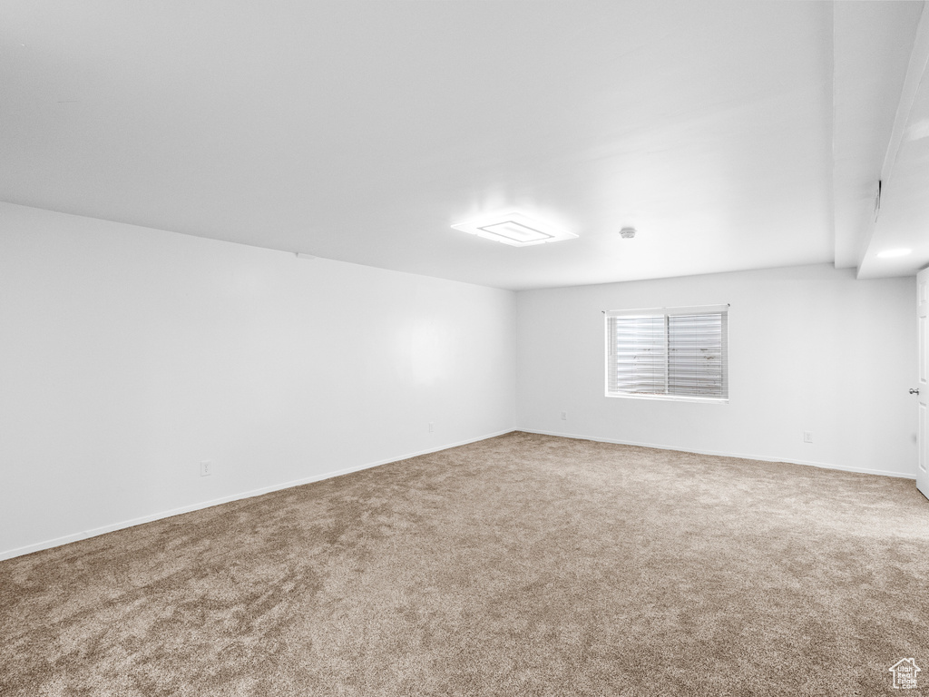 Spare room featuring carpet and baseboards