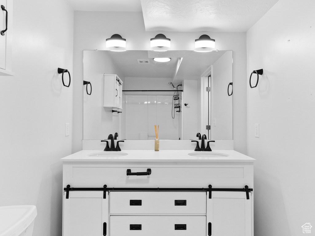 Full bathroom with double vanity and a shower