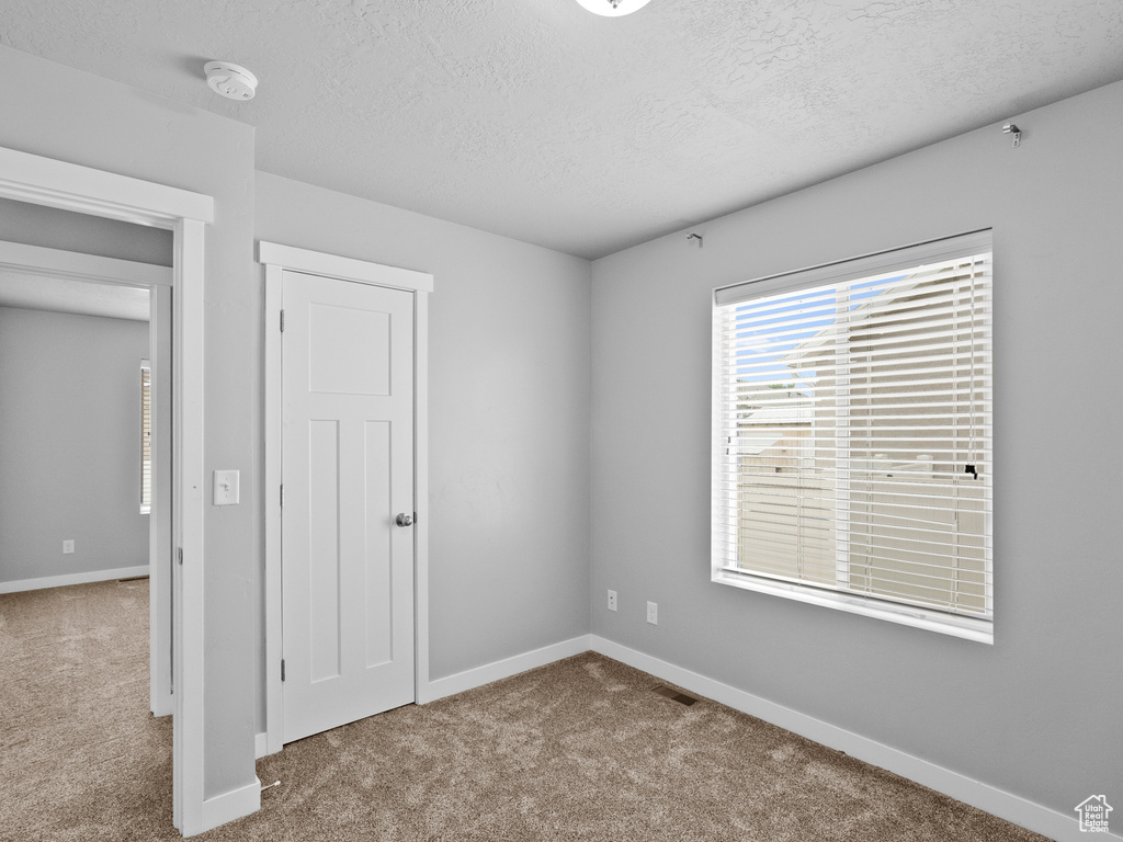 Unfurnished bedroom featuring carpet floors and a textured ceiling