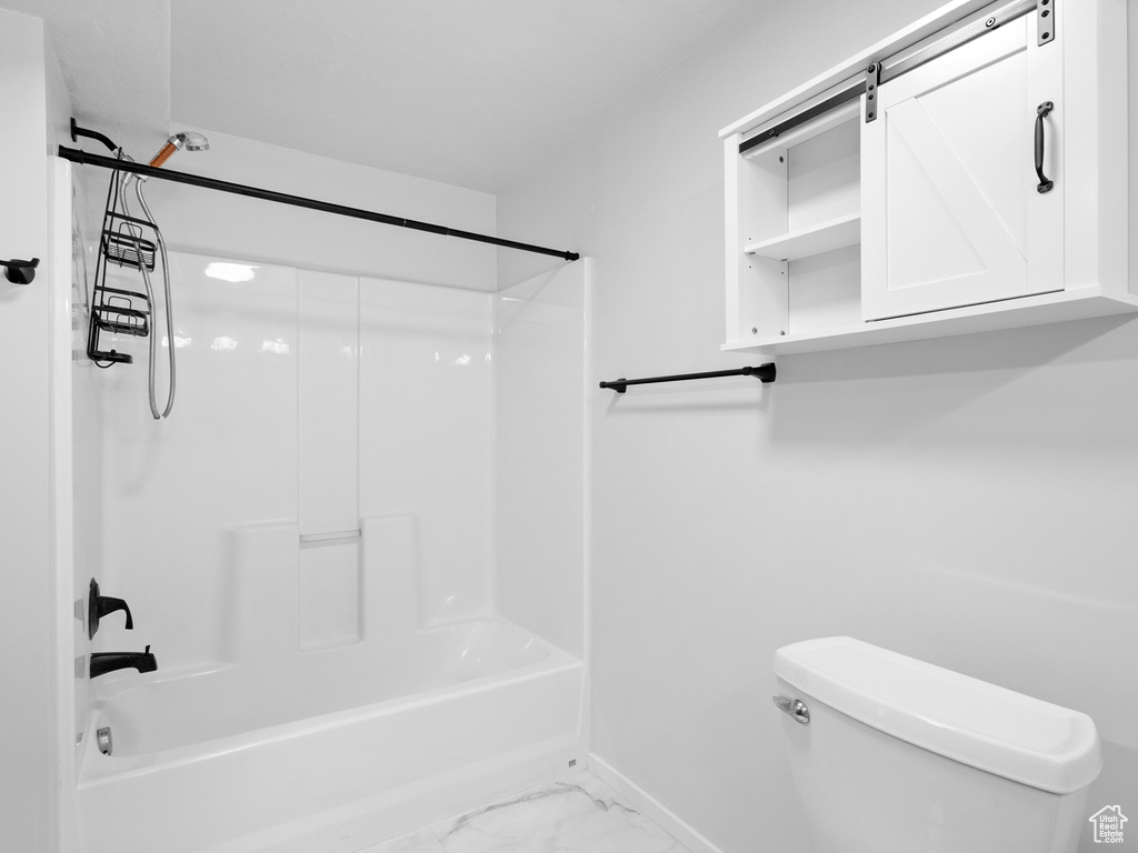 Full bath with washtub / shower combination and marble look tiles