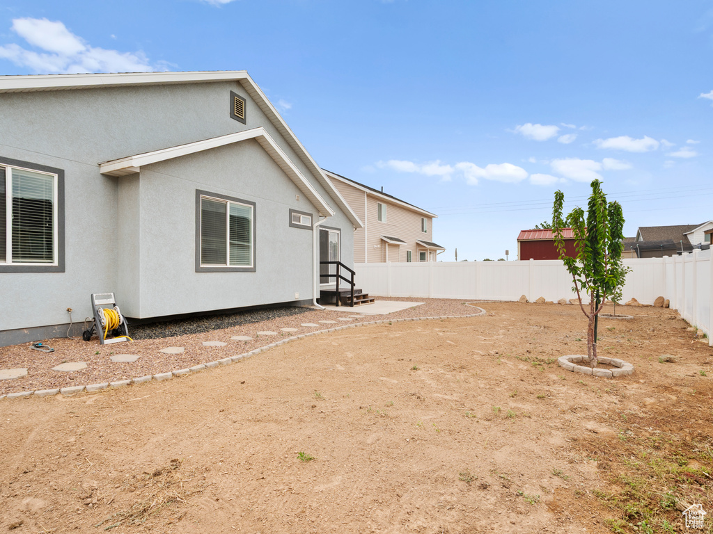 Fenced backyard featuring entry steps