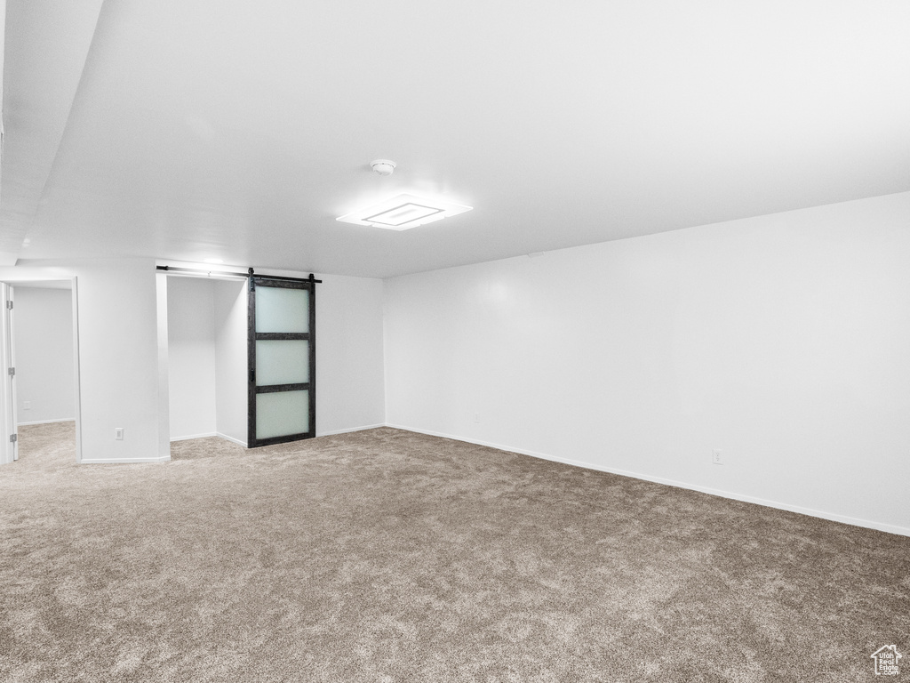Spare room featuring carpet floors and a barn door