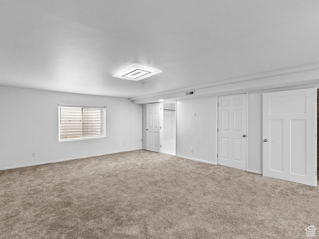 Unfurnished bedroom featuring carpet flooring and multiple closets