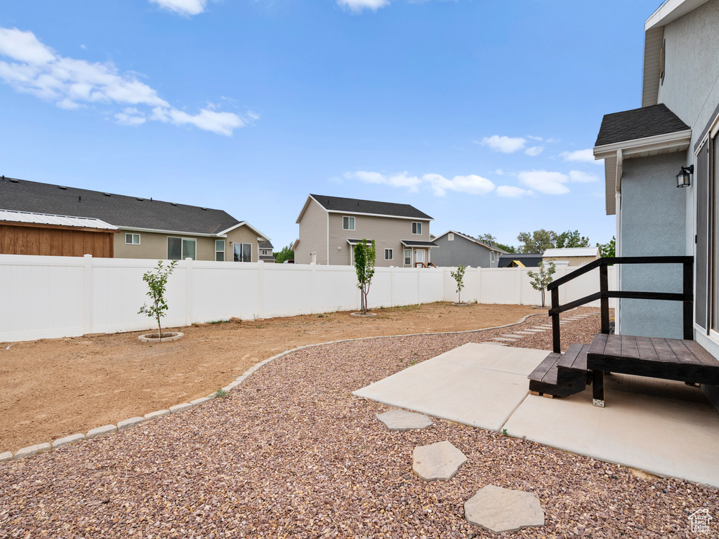 Fenced backyard featuring a patio area and a residential view