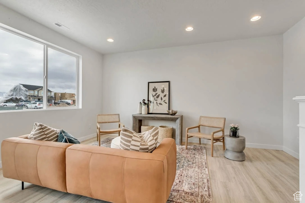 Living area featuring wood finished floors, plenty of natural light, recessed lighting, and a fireplace