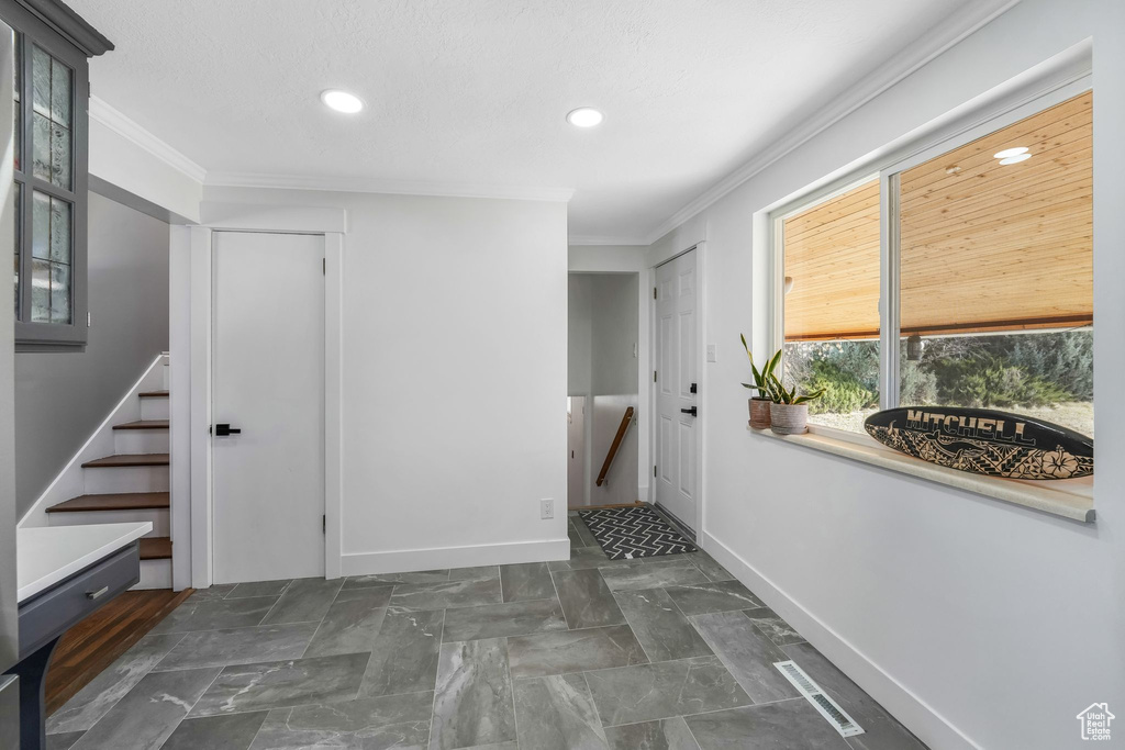 Hall featuring ornamental molding, recessed lighting, and stairway