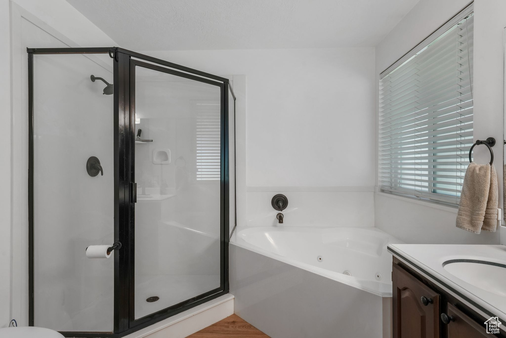 Full bathroom with a whirlpool tub, a shower stall, and vanity