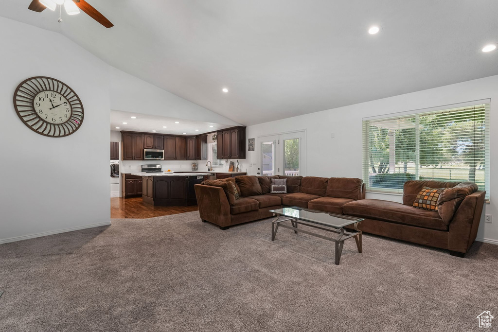 Living room with carpet, washer and clothes dryer, recessed lighting, ceiling fan, and high vaulted ceiling