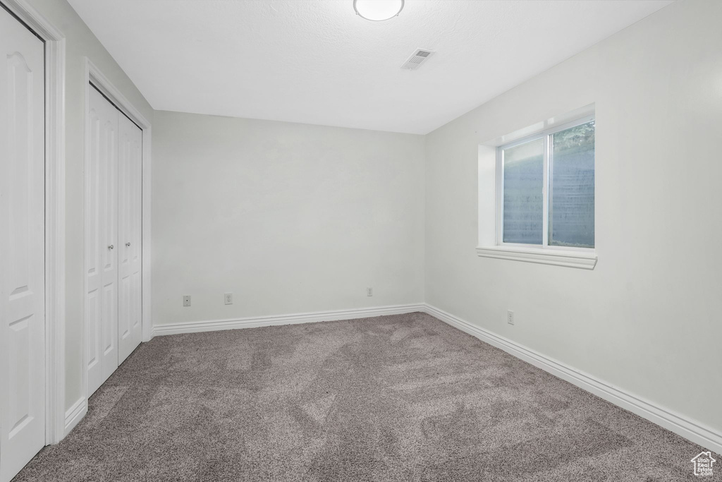 Unfurnished bedroom featuring carpet floors and a closet