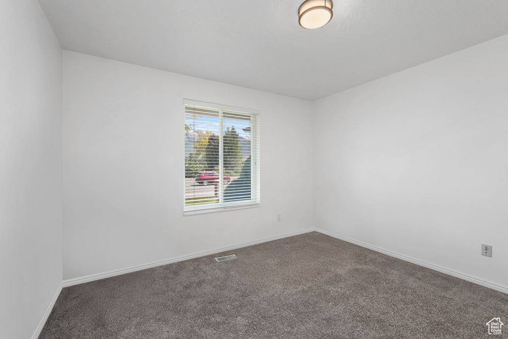 Carpeted spare room with baseboards