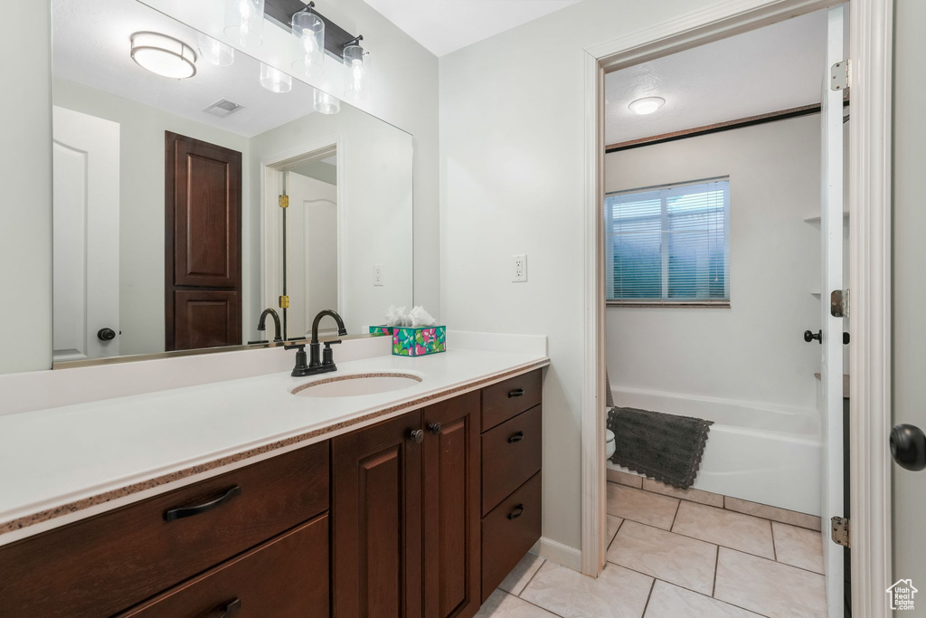 Bathroom with vanity, a tub to relax in, and tile patterned floors