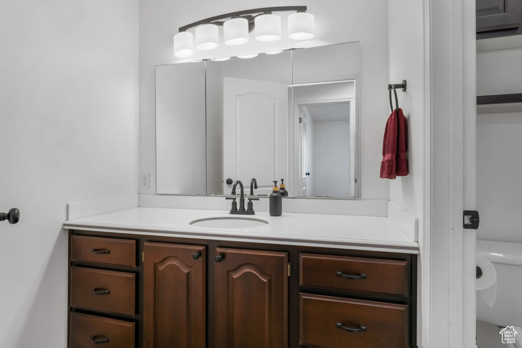 Half bathroom featuring vanity and toilet