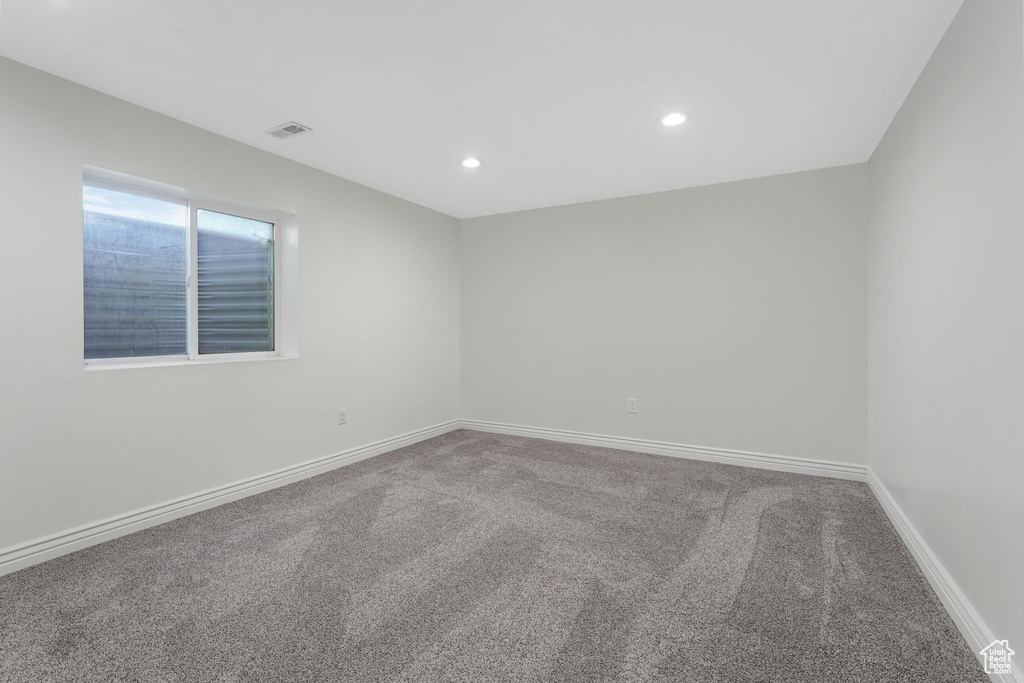Carpeted empty room featuring recessed lighting and baseboards