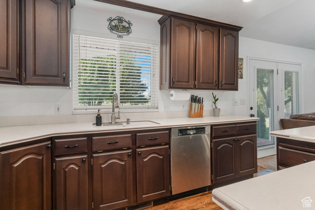 Kitchen with dishwasher, dark brown cabinets, plenty of natural light, and light countertops