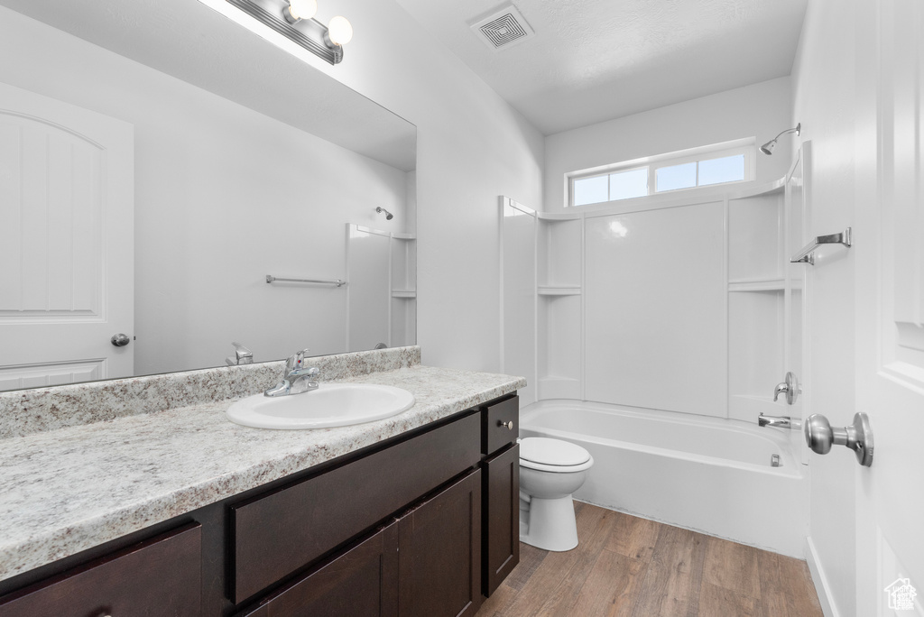 Full bath with vanity, wood finished floors, and shower / bath combination