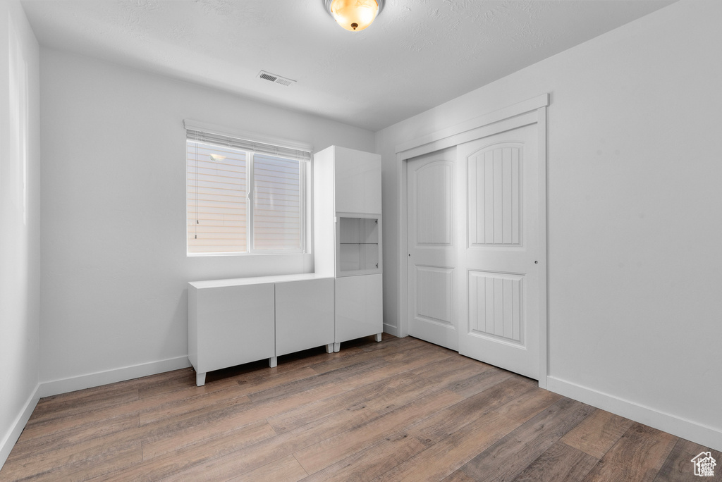 Unfurnished bedroom featuring wood finished floors and a closet